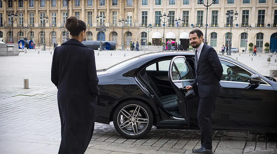 A driver from My Daily Driver company opens the door for a customer at Place Vendôme in Paris